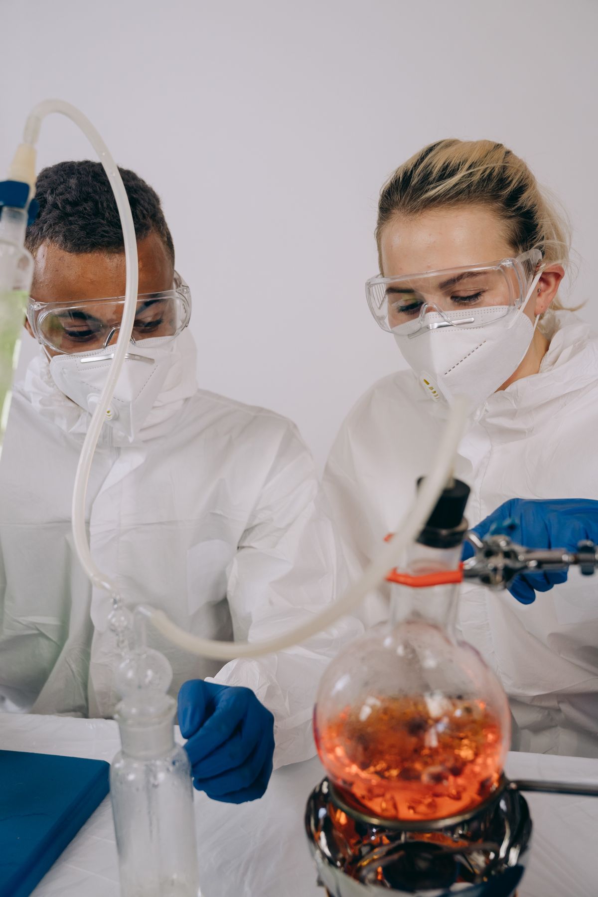 Two scientists handling glassware in a laboratory