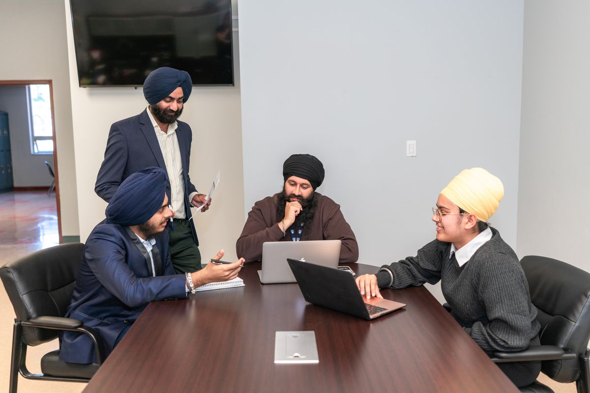 Sikh professionals in a conference-room laptop meeting